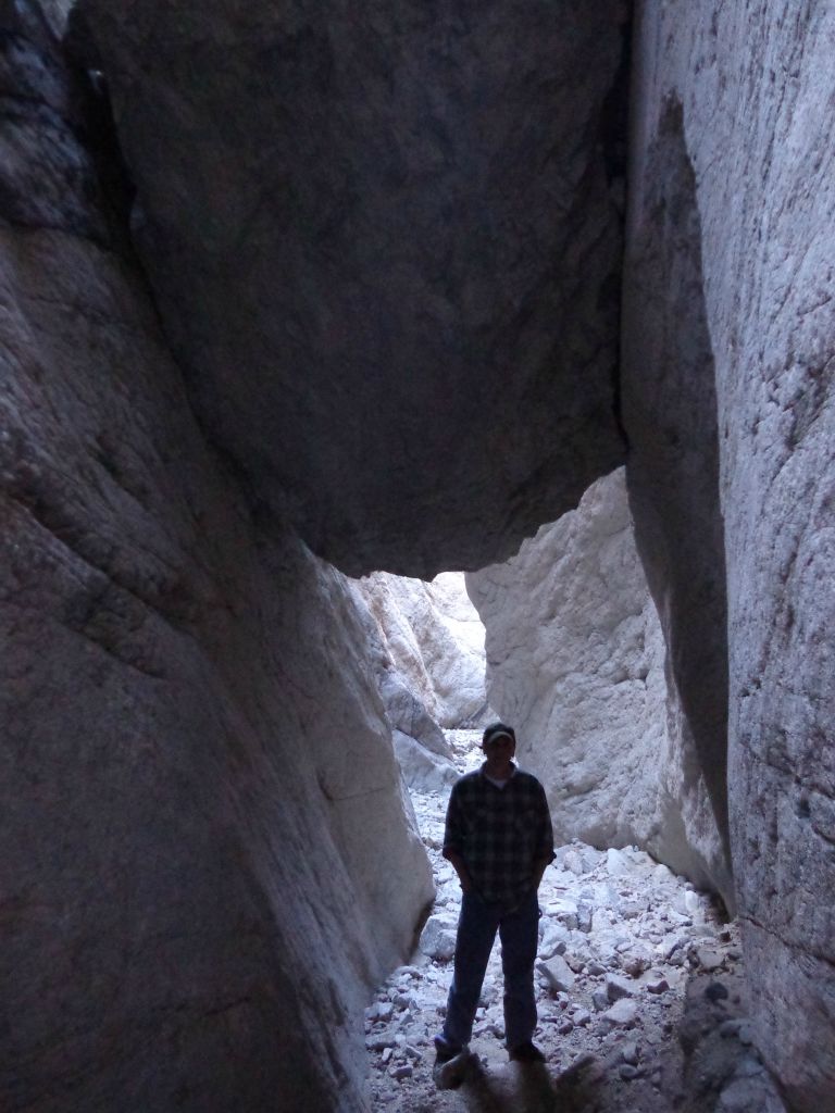 Charlie in the shadows underneath the second wedged boulder: