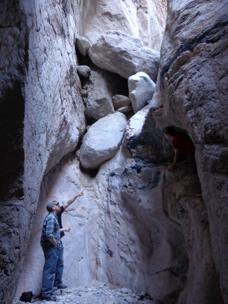 Our group analyzing the major dry fall.  On the right, you can see Jered inside a small cave partway up.  Our group realized that it was too dangerous to attempt a climb, so we all stopped our hike here.  The rest of the canyon is only accessible to professional climbers or canyoneers: