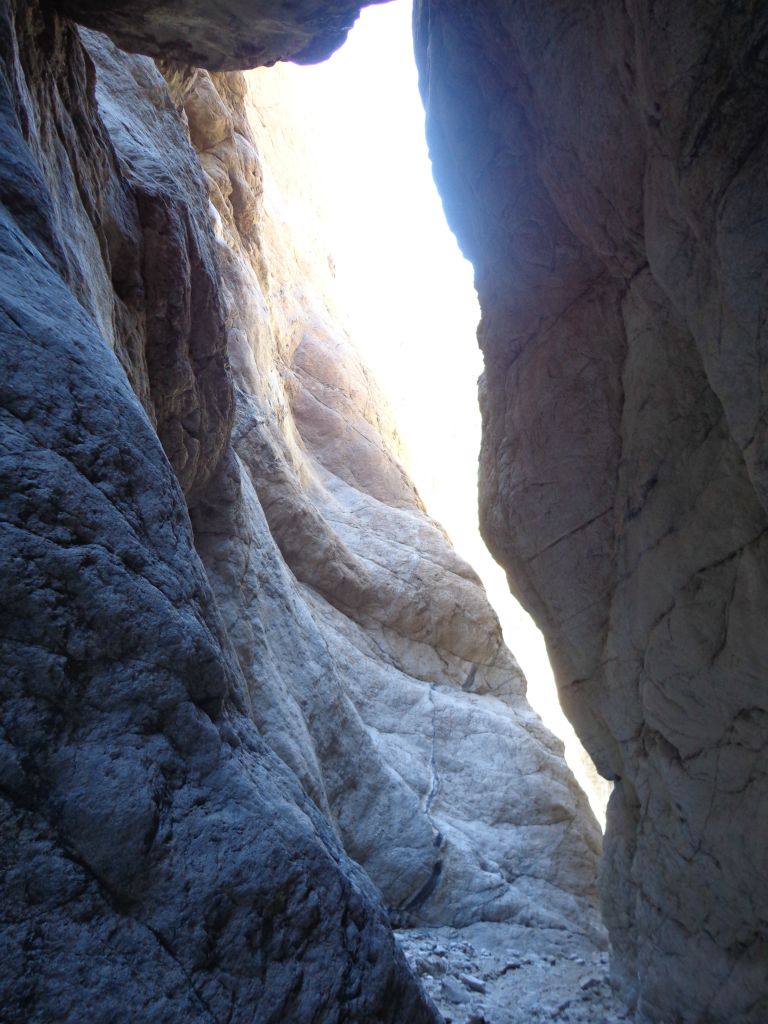 Passing underneath the first boulder on the way back out the slot: