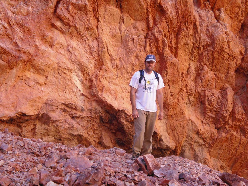 Steve getting a picture next to the extremely vivid orange wall: