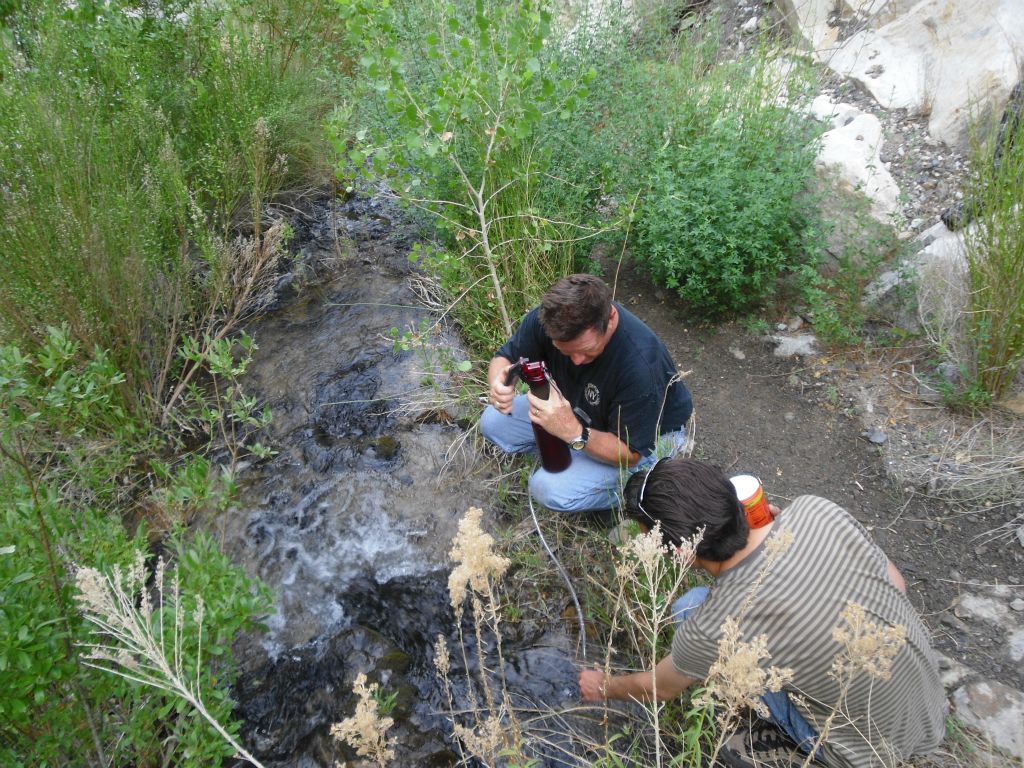 Gary is pumping water out of the creek through his filter.  Andrew is also pictured here holding some valuable Gatorade mix which aids hiking in hot weather: