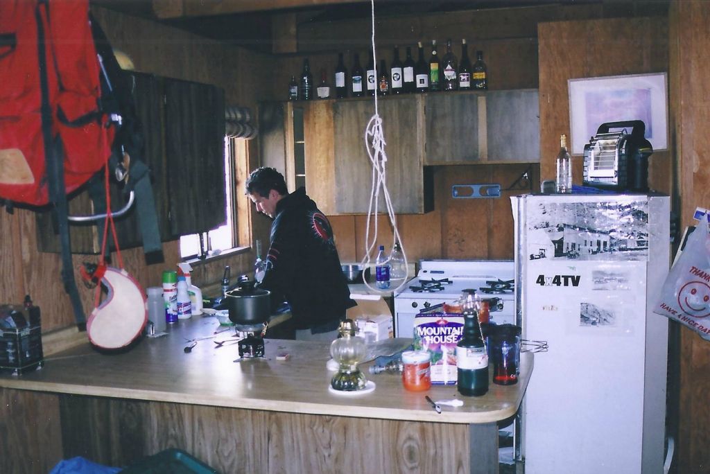 Silva preparing to cook dinner in the Hilton.  The water in the sink was running on our first trip there.  For our second trip, we had to get the water outside from a pump in the machine shop.  As of 2015, you may have to hike over to Water Canyon to get water: