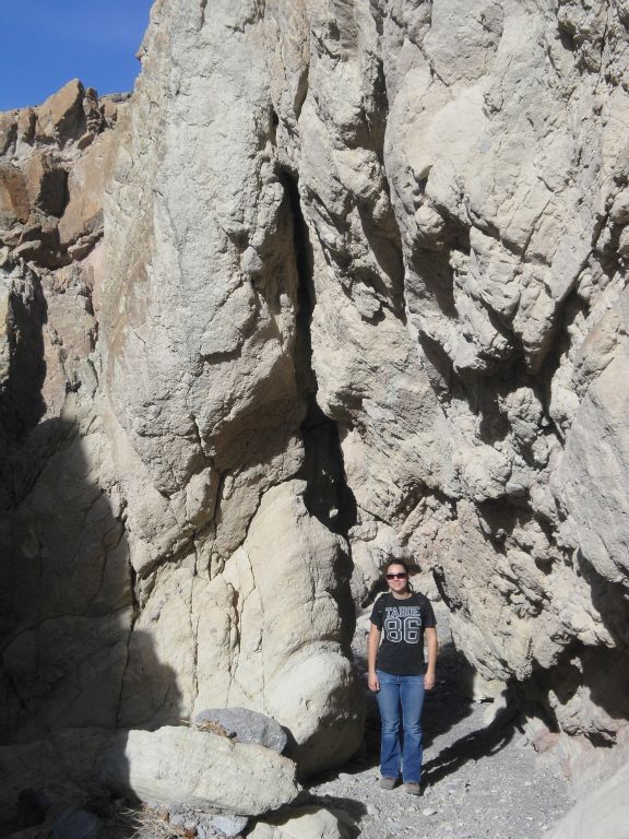 Tiffany standing in front of a natural bridge at the junction with another small canyon: