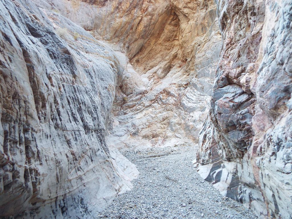 A small gravel wash gives way to rock steps: