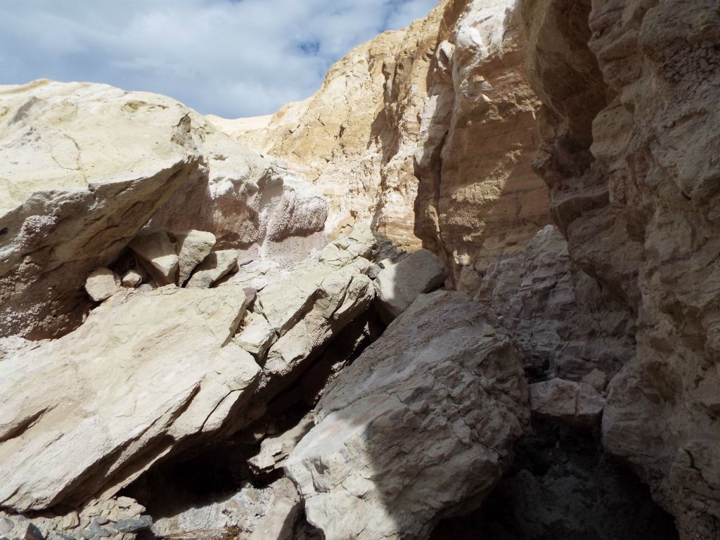 A wall of the side canyon which has completely collapsed and formed a maze of massive boulders: