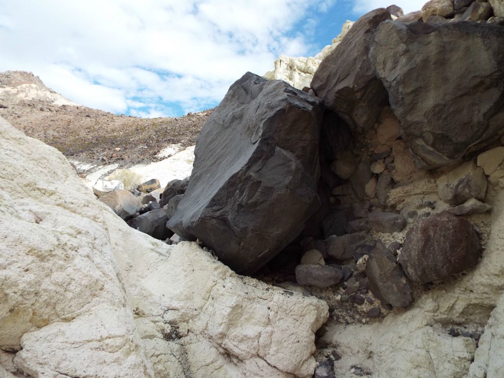 Passing by some huge boulders and slabs of black rock: