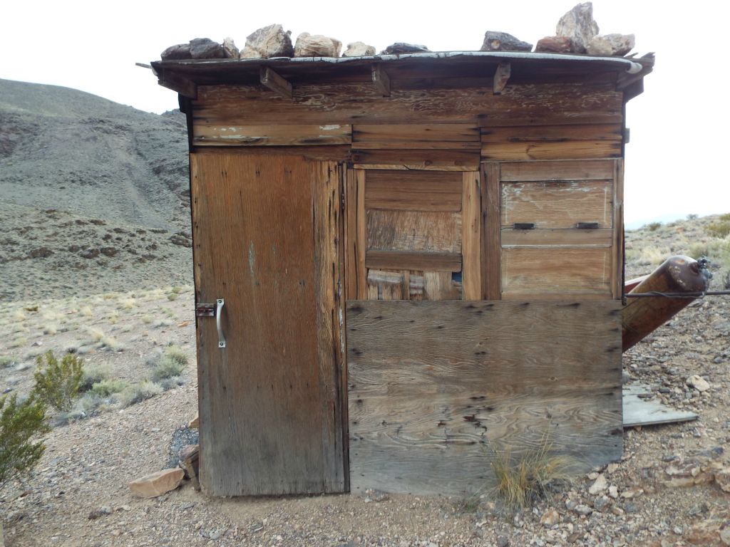 Note the roof outside of the southern side of the cabin.  Boulders have been placed on the roof to prevent it from being blown off in windstorms: